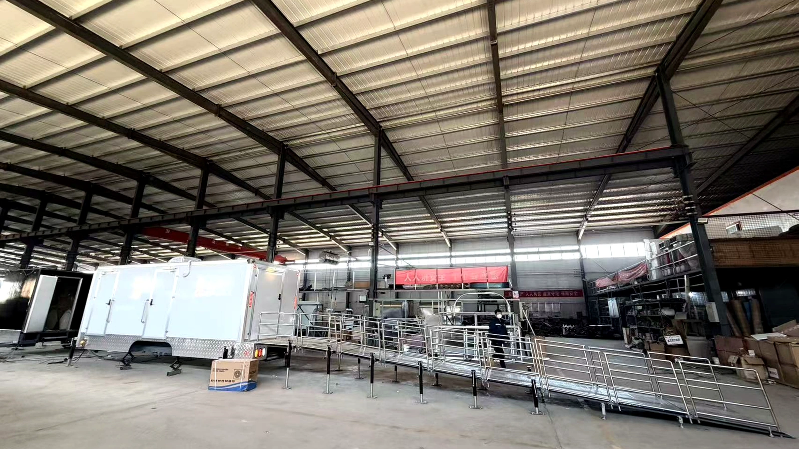 Close-up of ADA restroom trailer ramp with stainless steel handrails and anti-slip aluminum platform.