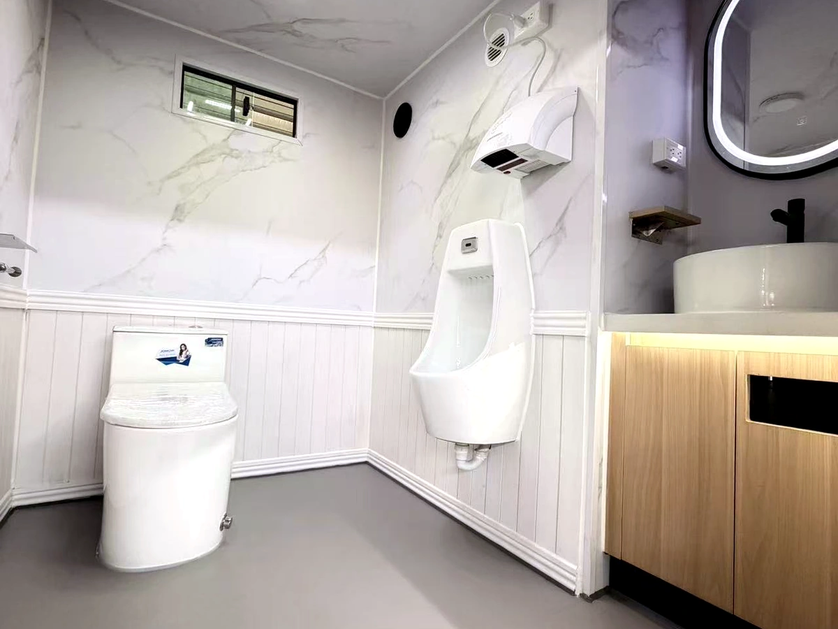 Men’s room interior of 2 stall plus ADA restroom trailer with urinal, sink, mirror, and hand dryer